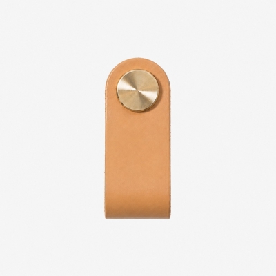 Maniglia per mobile in ottone rivestita in pelle bovina.
