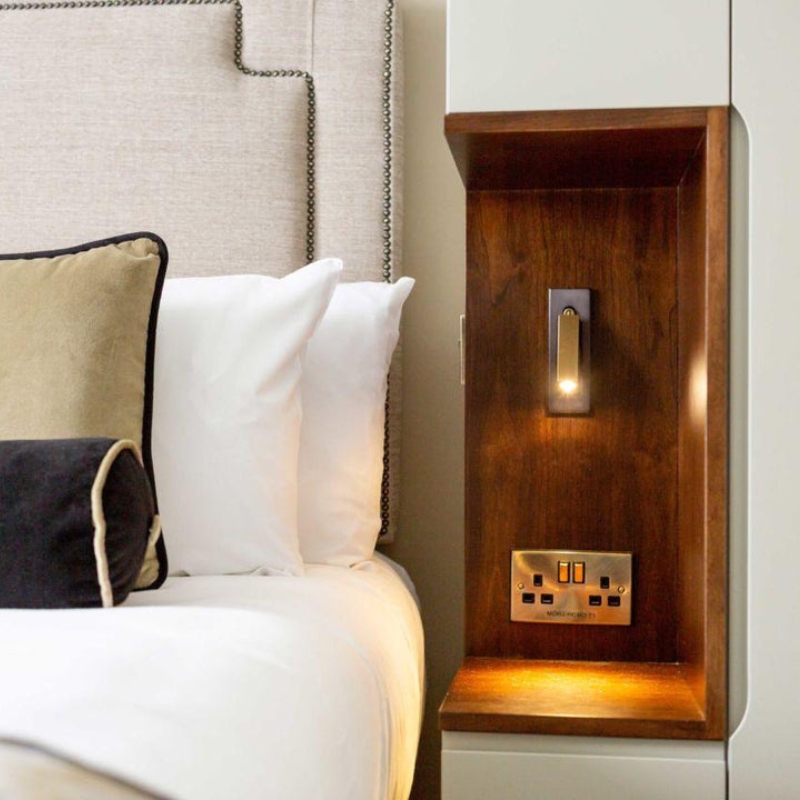 L&aacute;mpara de pared empotrada junto a la cama
