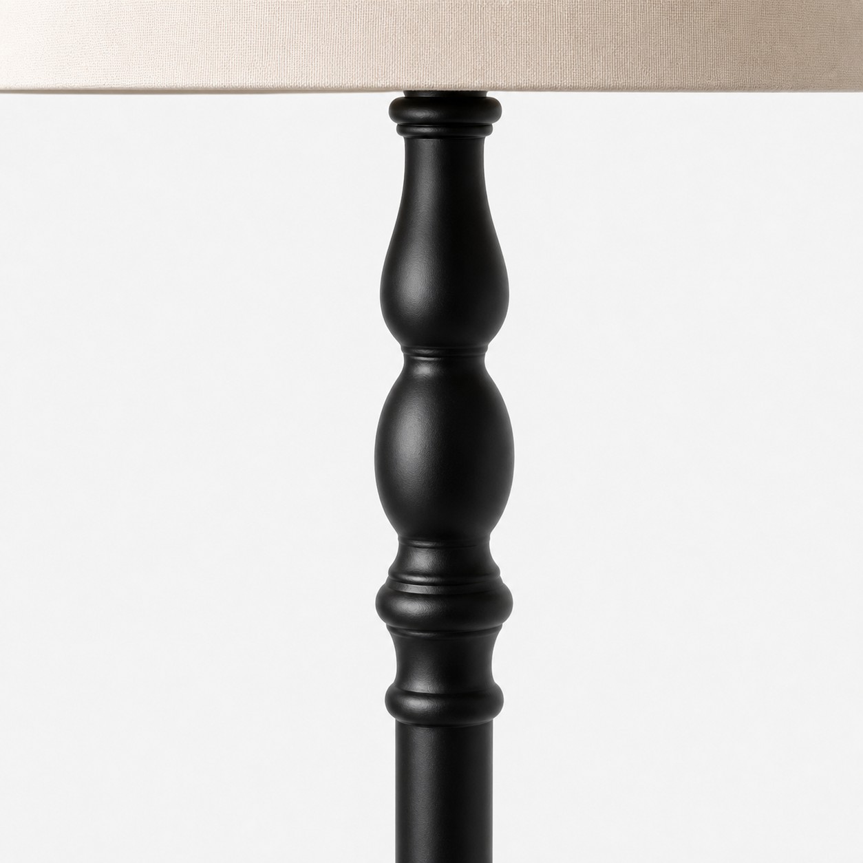 L&aacute;mpara de pie de madera torneada con pantalla de tela.