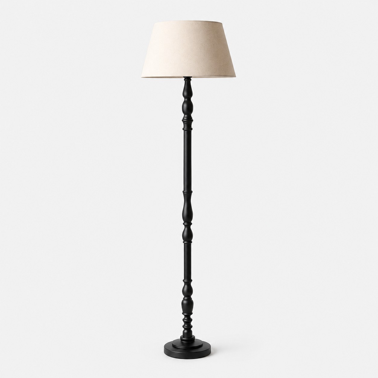L&aacute;mpara de pie de madera torneada con pantalla de tela.